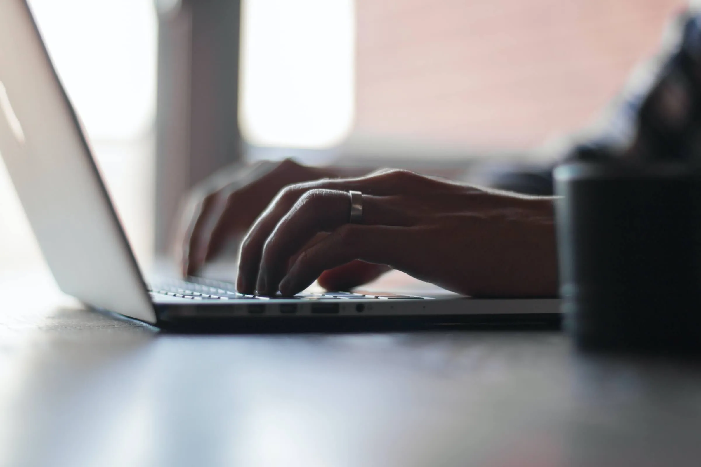 Hände tippen auf der Tastatur eines Laptops
